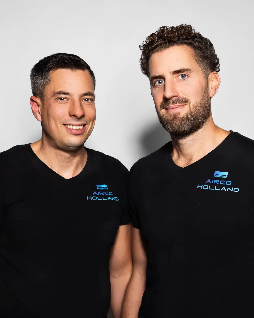 Peter (links) en Rein (rechts) van Airco Holland, lachend in zwarte shirts met het logo.